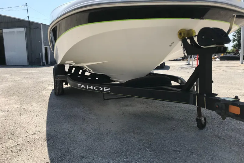 Slide: The Image of Trailer for 2021 Tahoe 1950 boat parked outdoors on gravel surface. - 7
