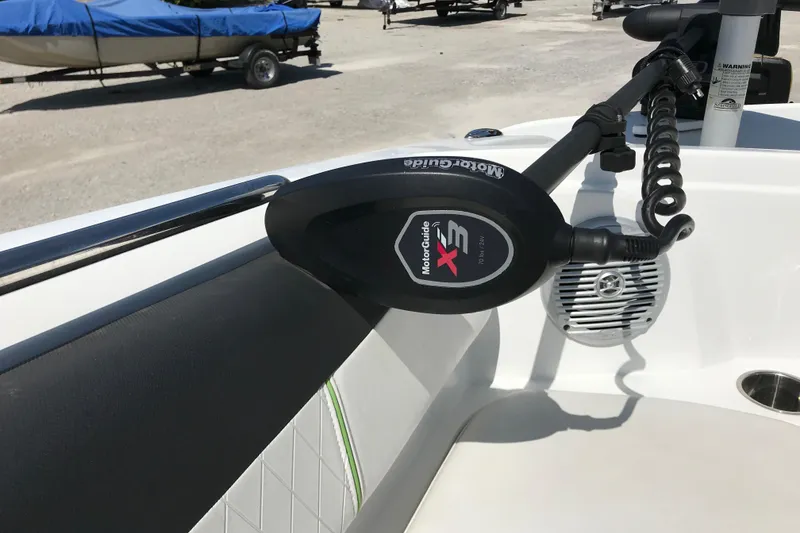 Slide: The Image of MotorGuide X3 trolling motor on 2021 Tahoe 1950 boat, docked with covered boats nearby. - 17
