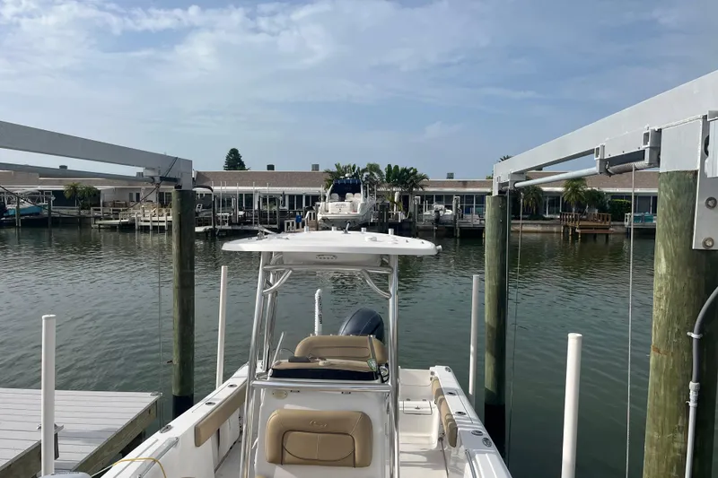 Slide: The Image of 2017 Sportsman Open 212 Center Console boat docked at a marina with waterfront view. - 33
