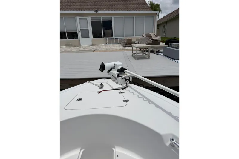Slide: The Image of 2017 Sportsman Open 212 Center Console boat docked near a modern patio. - 19