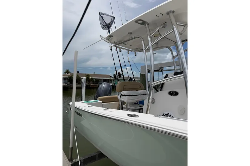 Slide: The Image of 2017 Sportsman Open 212 Center Console boat docked, featuring fishing rods and a T-top. - 5