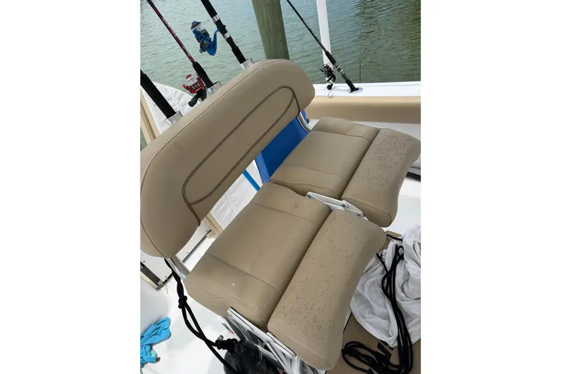 Slide: The Image of 2017 Sportsman Open 212 Center Console boat seat with fishing rods in background. - 22