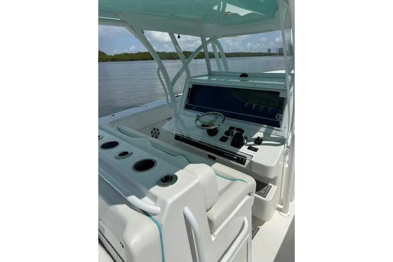 Slide: The Image of 2016 SeaHunter 41 Tournament boat cockpit with steering wheel and control panel, on calm water. - 17