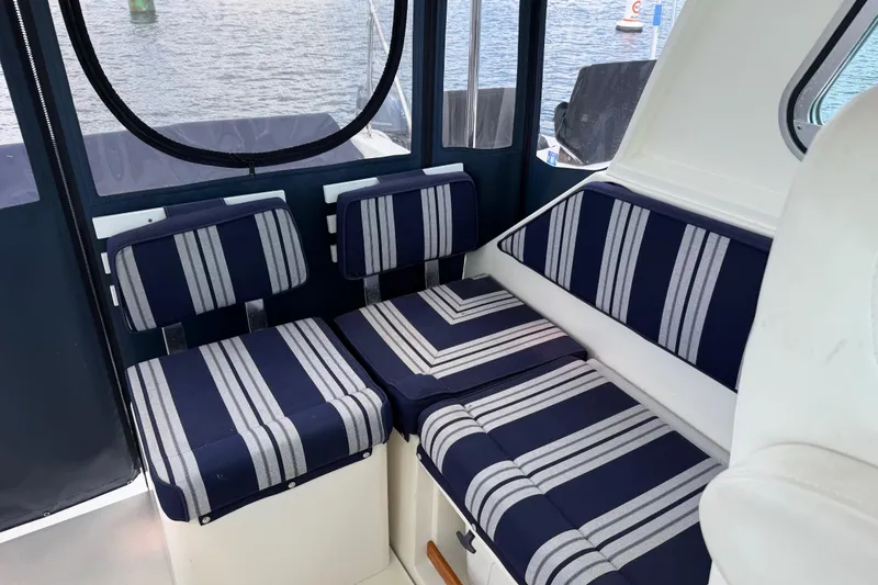 Slide: The Image of 2004 Back Cove 29 boat interior with striped seating, overlooking water. - 7