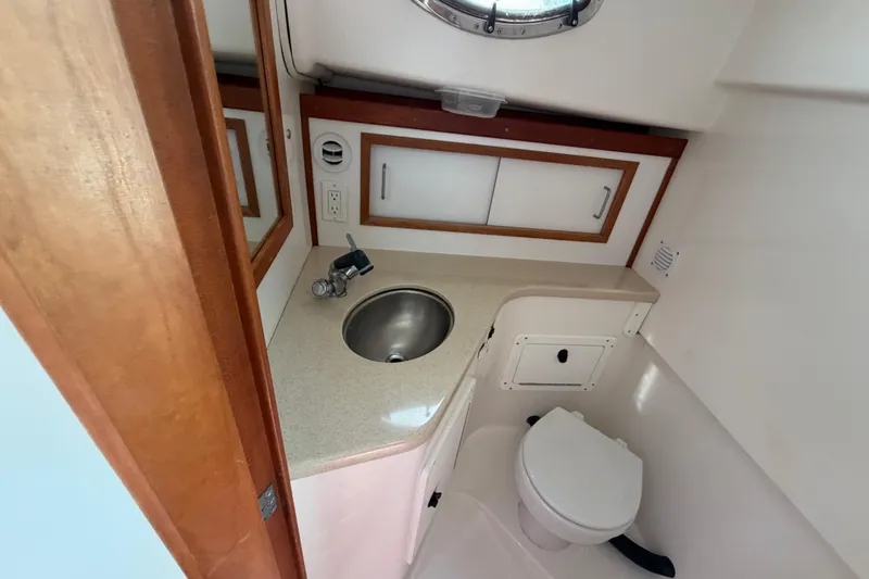 Slide: The Image of Compact bathroom in 2004 Back Cove 29 boat with sink, toilet, and storage cabinets. - 16