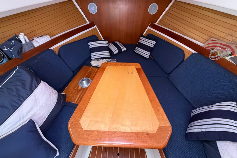 Slide: The Image of Cozy interior of 2004 Back Cove 29 boat with blue cushions and wooden table. - 18