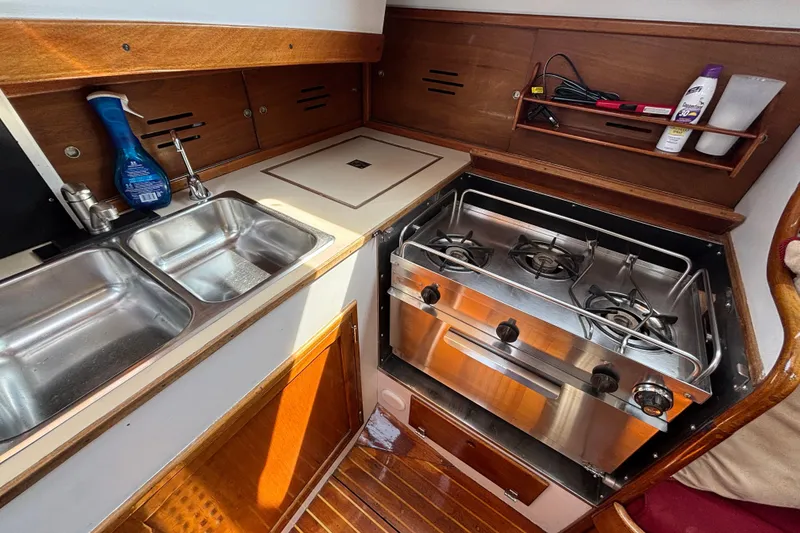 Slide: The Image of 1974 Hinckley Bermuda 40 MKIII yacht kitchen with dual sink and stainless steel stove. - 29