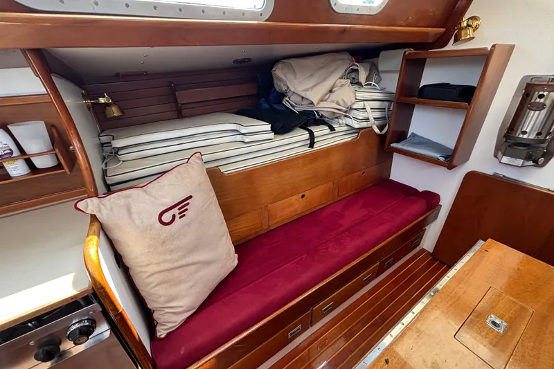 Slide: The Image of Interior of 1974 Hinckley Bermuda 40 MKIII sailboat with wooden furnishings and red cushion. - 27