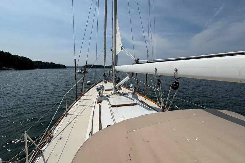 Slide: The Image of 1974 Hinckley Bermuda 40 MKIII sailboat on calm waters under a clear sky. - 12