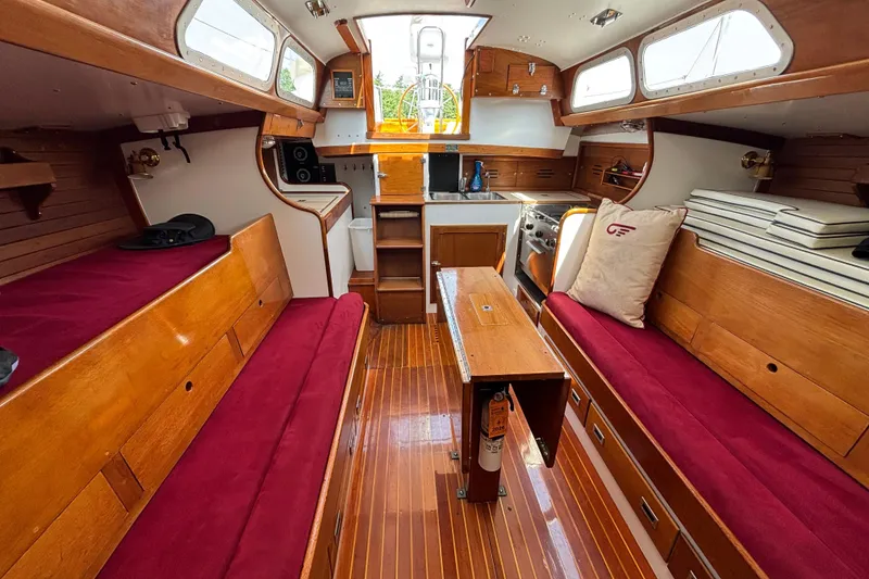 Slide: The Image of Interior of a 1974 Hinckley Bermuda 40 MKIII sailboat with wooden finishes and red cushions. - 25