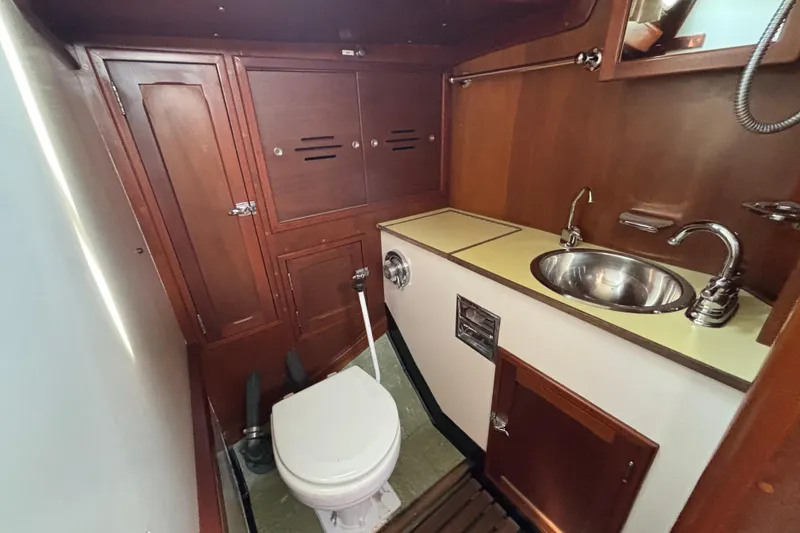Slide: The Image of 1974 Hinckley Bermuda 40 MKIII yacht bathroom with wooden cabinetry and stainless steel sink. - 41