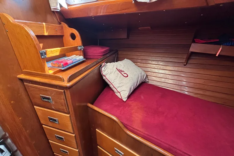 Slide: The Image of Cozy cabin interior of 1974 Hinckley Bermuda 40 MKIII with wooden finish and red bedding. - 39