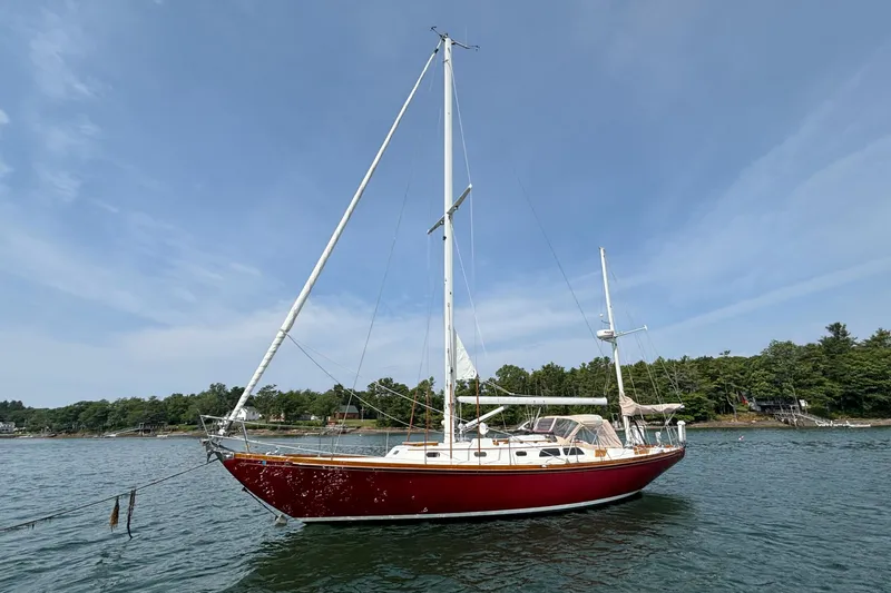 The Image of 1974 Hinckley Bermuda 40 MKIII sailboat with red hull on calm water. - 0