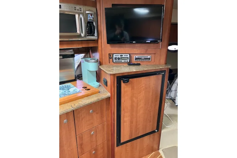 Slide: The Image of 2009 Cruisers Yachts 360 Express interior with TV, microwave, and wooden cabinetry. - 42