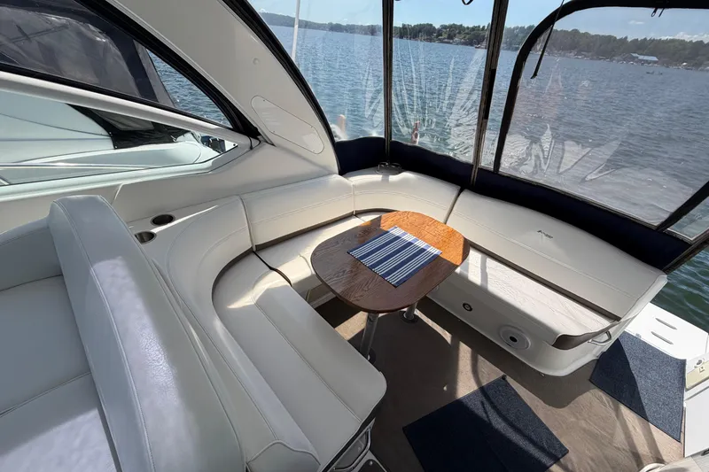 Slide: The Image of 2009 Cruisers Yachts 360 Express interior with white seating and wooden table, overlooking water. - 19