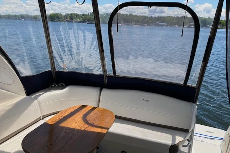 Slide: The Image of 2009 Cruisers Yachts 360 Express interior with lake view, featuring white seating and wooden table. - 20