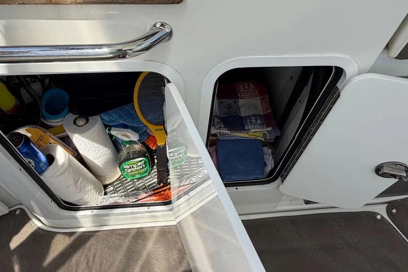 Slide: The Image of Storage compartments on a 2009 Cruisers Yachts 360 Express, containing cleaning supplies and towels. - 57