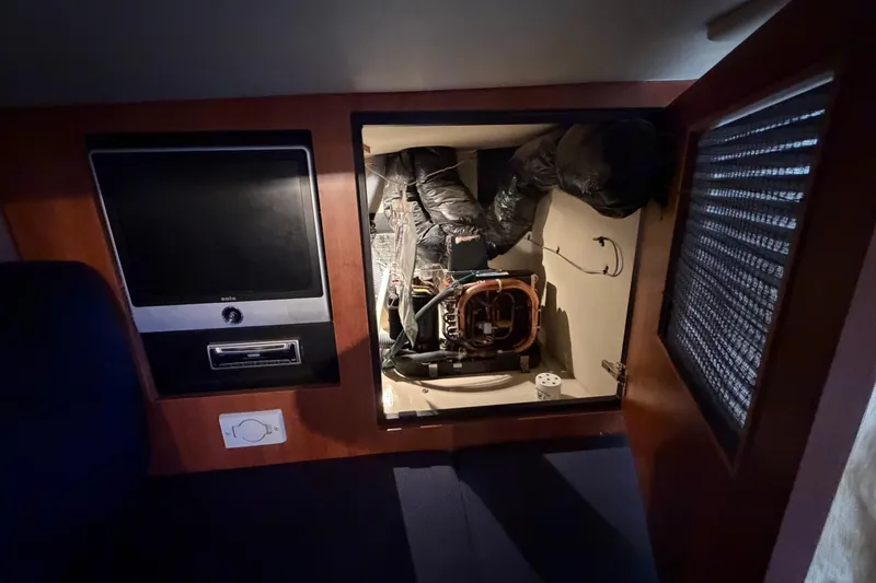 Slide: The Image of 2009 Cruisers Yachts 360 Express interior showing electronic equipment and storage compartment. - 64