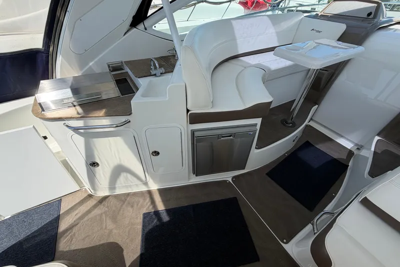 Slide: The Image of 2009 Cruisers Yachts 360 Express interior with seating, table, and kitchenette area. - 23