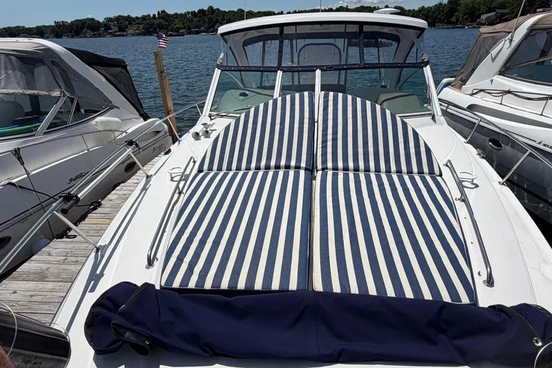 Slide: The Image of 2009 Cruisers Yachts 360 Express with striped sun pads docked by the lake. - 8