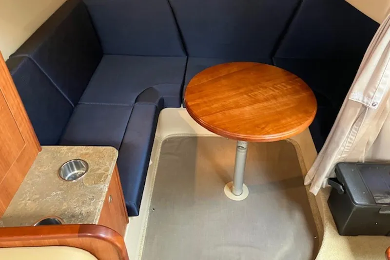 Slide: The Image of 2009 Cruisers Yachts 360 Express interior with blue seating and wooden table. - 33