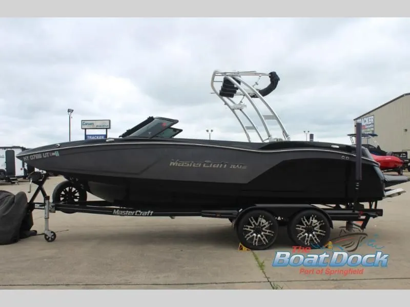 Slide: The Image of Black MasterCraft NXT 22 motorboat on a trailer, side view in a parking lot. - 5