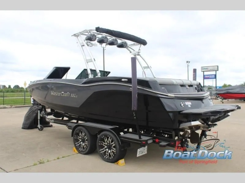 Slide: The Image of A black motorboat, MasterCraft NXT 22 model, is on a trailer in a parking lot. - 6
