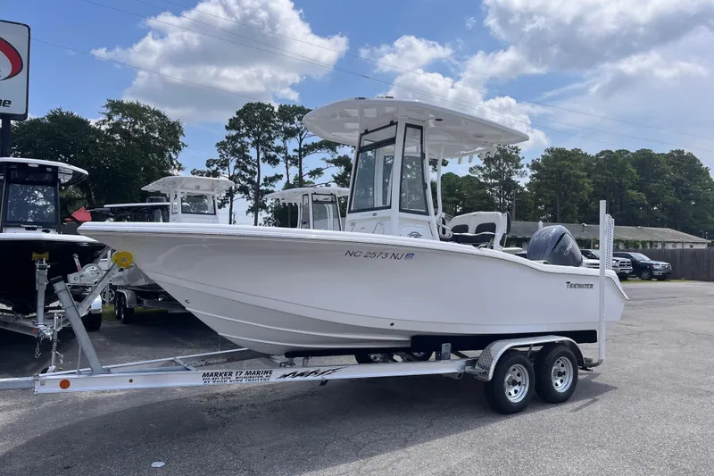 Slide: The Image of 2026 Tidewater 210 CC Adventure boat on trailer, parked outdoors under a cloudy sky. - 1