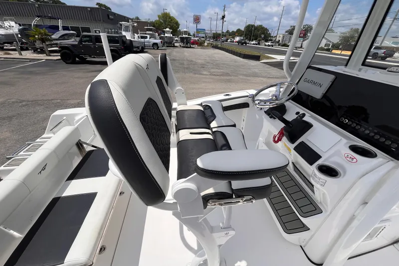Slide: The Image of 2026 Tidewater 210 CC Adventure boat interior with steering console and seating. - 7