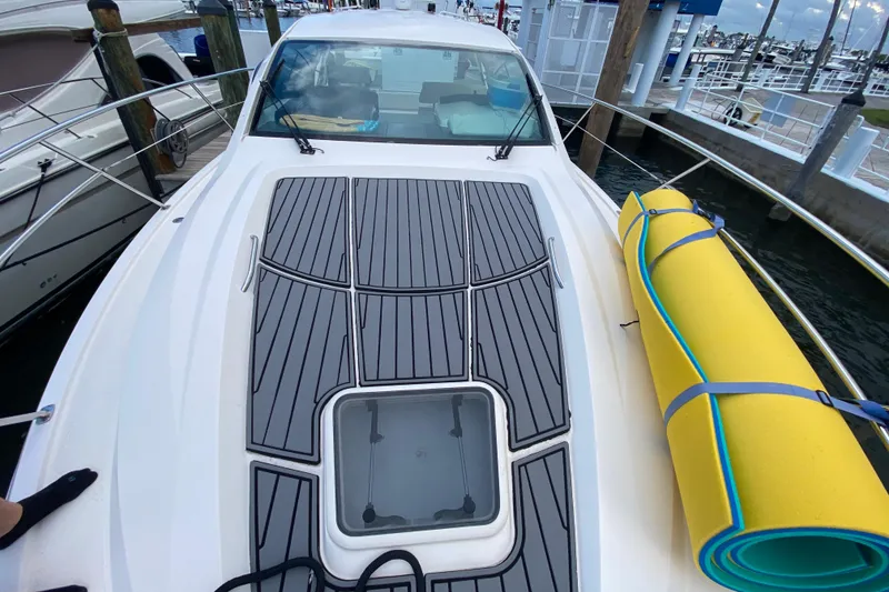 Slide: The Image of 2014 Pursuit SC 365i Sport Coupe docked, featuring deck and rolled yellow mat. - 19