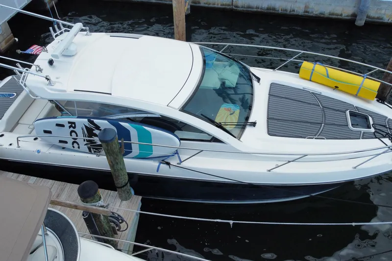 Slide: The Image of 2014 Pursuit SC 365i Sport Coupe docked with paddleboard and yellow float. - 8