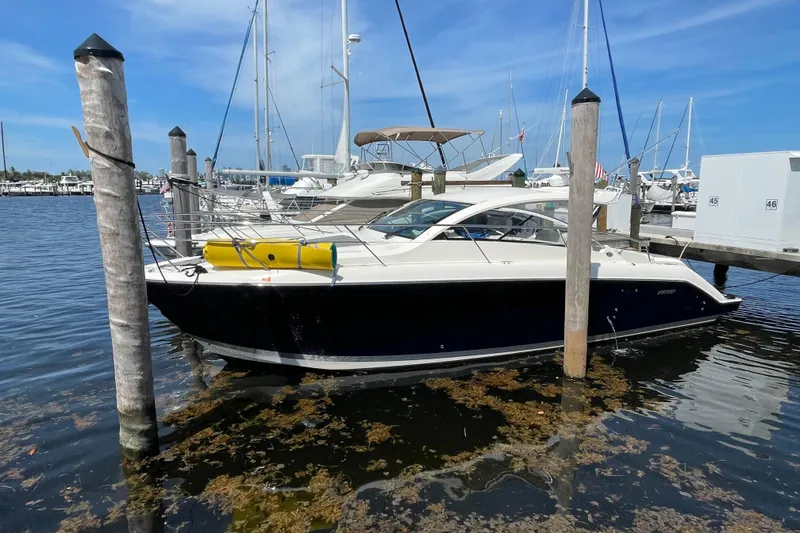 Slide: The Image of 2014 Pursuit SC 365i Sport Coupe docked at marina, surrounded by sailboats. - 64