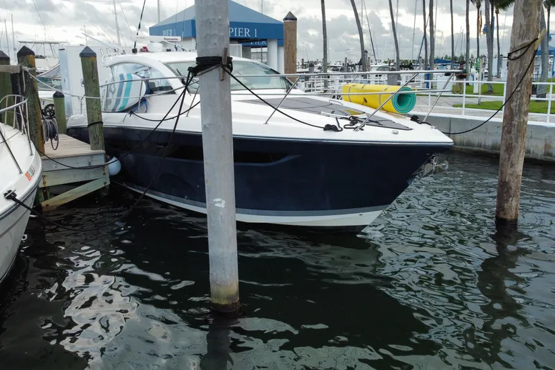 Slide: The Image of 2014 Pursuit SC 365i Sport Coupe docked at marina, calm water, overcast sky. - 6