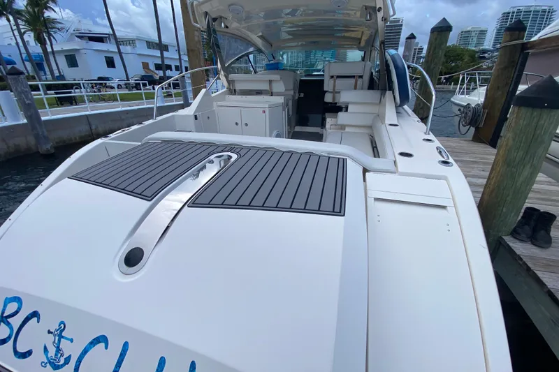 Slide: The Image of 2014 Pursuit SC 365i Sport Coupe docked, showcasing spacious deck and seating area. - 27