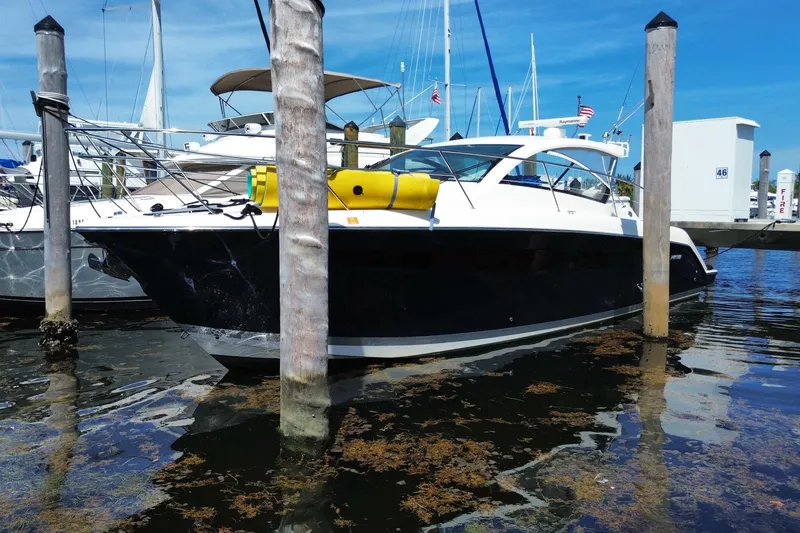 Slide: The Image of 2014 Pursuit SC 365i Sport Coupe docked at marina, surrounded by sailboats. - 13
