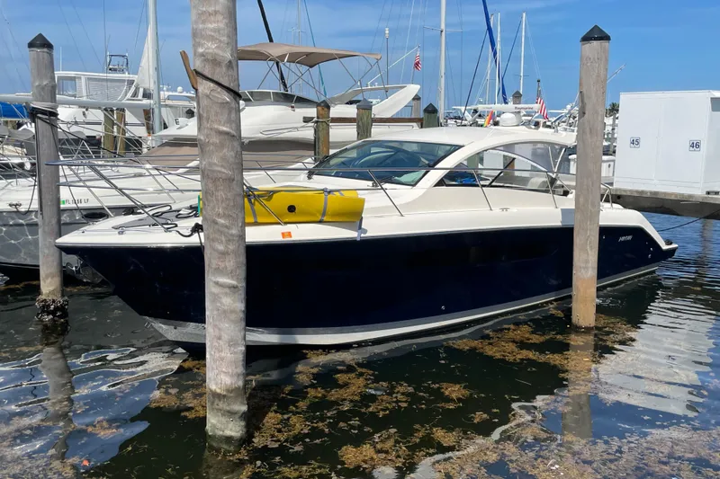 Slide: The Image of 2014 Pursuit SC 365i Sport Coupe docked at marina, surrounded by other boats. - 3