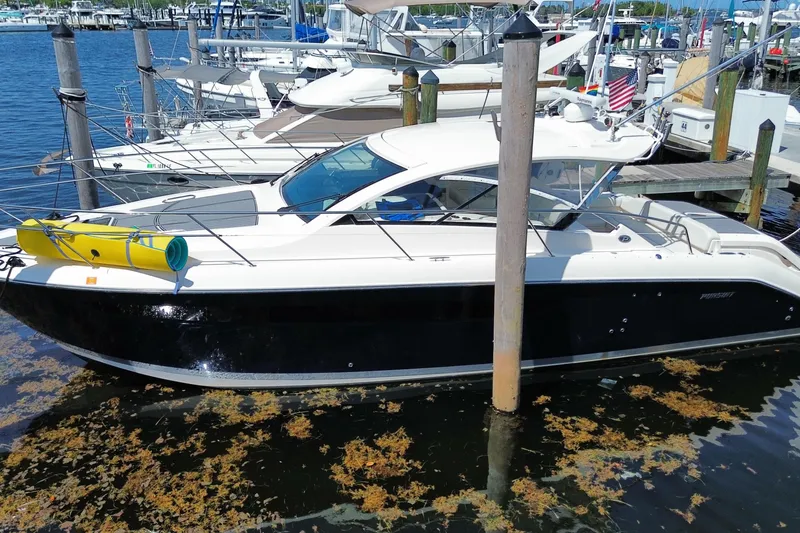 The Image of 2014 Pursuit SC 365i Sport Coupe docked at marina, featuring sleek design and vibrant surroundings. - 0