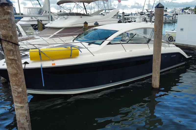 Slide: The Image of 2014 Pursuit SC 365i Sport Coupe docked at a marina with other boats. - 14