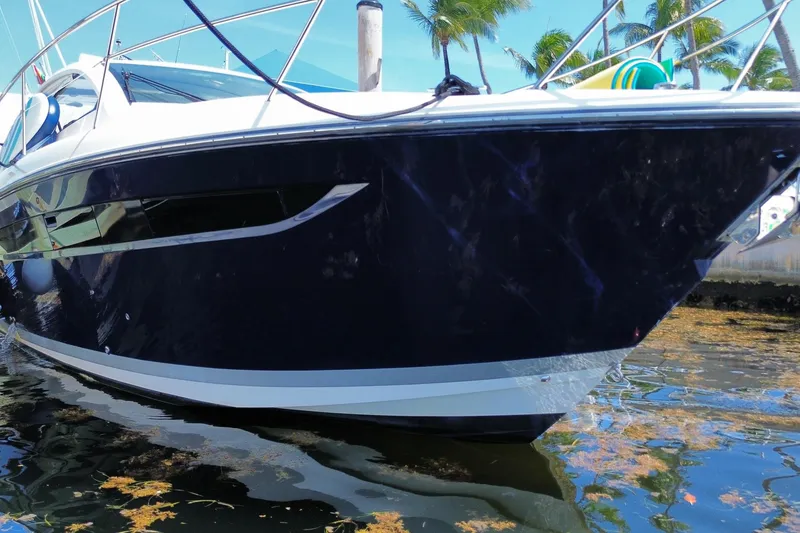 Slide: The Image of 2014 Pursuit SC 365i Sport Coupe yacht docked near palm trees. - 4