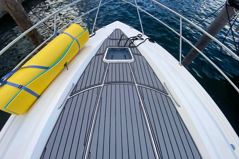 Slide: The Image of 2014 Pursuit SC 365i Sport Coupe deck with yellow mat, docked by water. - 20