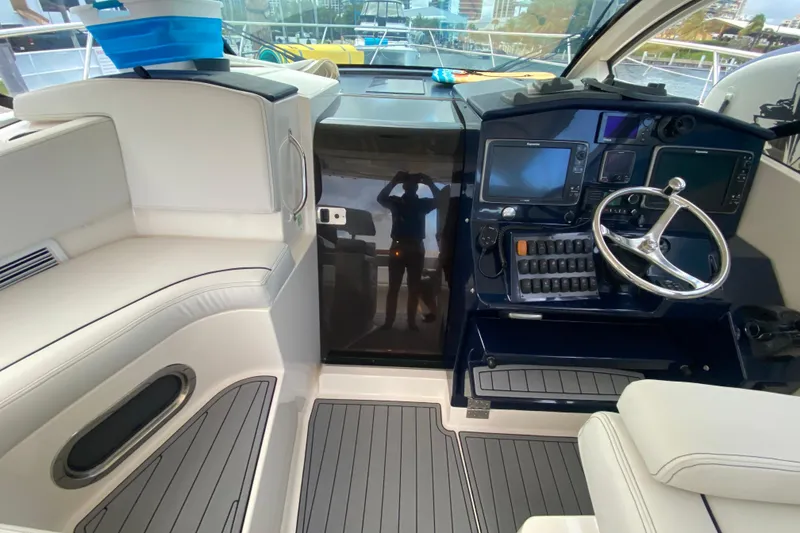 Slide: The Image of 2014 Pursuit SC 365i Sport Coupe interior with helm, seating, and navigation controls. - 39