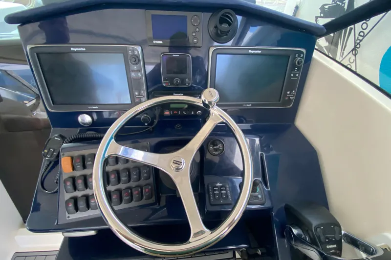 Slide: The Image of 2014 Pursuit SC 365i Sport Coupe helm with dual Raymarine displays and steering wheel. - 34