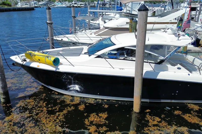 Slide: The Image of 2014 Pursuit SC 365i Sport Coupe docked at marina, surrounded by water and boats. - 73
