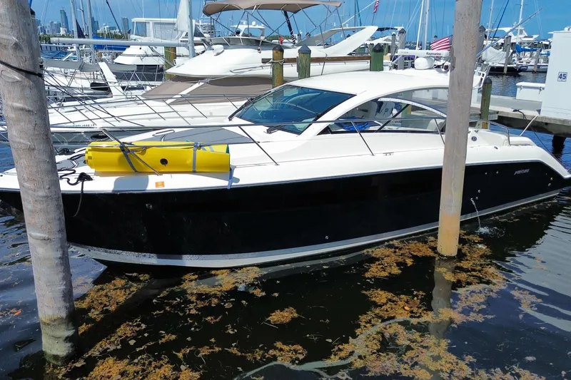 Slide: The Image of 2014 Pursuit SC 365i Sport Coupe docked at marina, surrounded by boats and clear blue sky. - 5