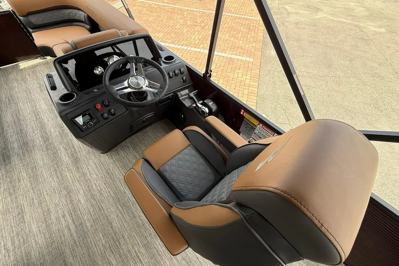 Slide: The Image of 2026 Bennington 21 SLJ boat interior with luxurious brown and black seating and modern dashboard. - 11