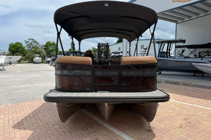 Slide: The Image of 2026 Bennington 21 SLJ pontoon boat with canopy, parked on brick pavement. - 2
