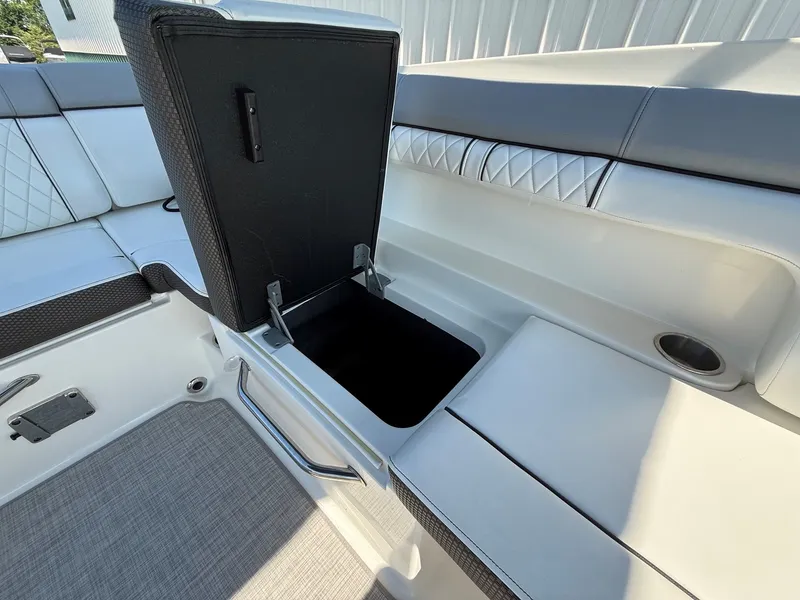 Slide: The Image of An open storage compartment on a 2017 Sea Ray SDX 290 boat, surrounded by cushioned seating. - 24
