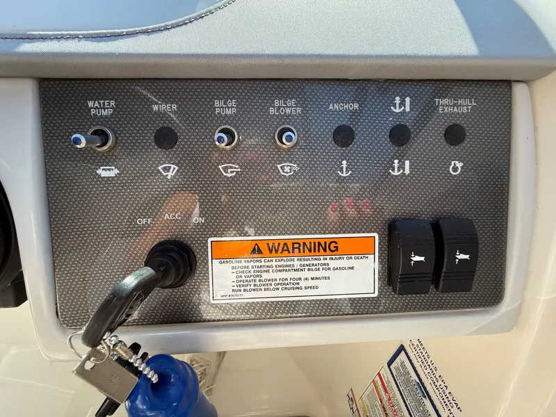 Slide: The Image of Control panel of a 2017 Sea Ray SDX 290 with various switches and warning labels. - 32