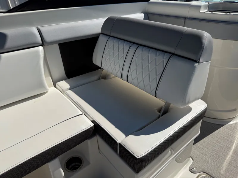 Slide: The Image of The 2017 Sea Ray SDX 290 features an elegant, cushioned bench seat with gray and white upholstery. - 17