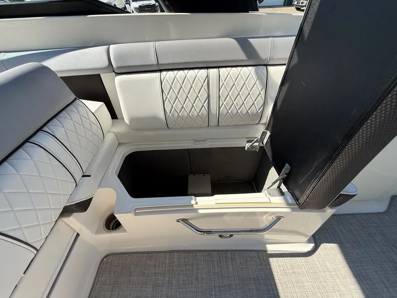 Slide: The Image of The 2017 Sea Ray SDX 290 features an open storage compartment beneath a cushioned seat. - 28